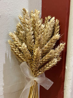 Beautifully tied miniature sheafs of corn tied with ribbon make us think of the farmers who bring in the harvest.