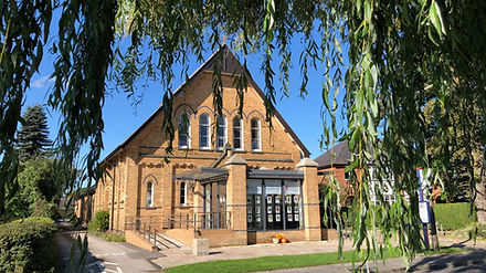 View of the Haxby and Wigginton Methodist Church, looking through willow trees across the Haxby duck pond.