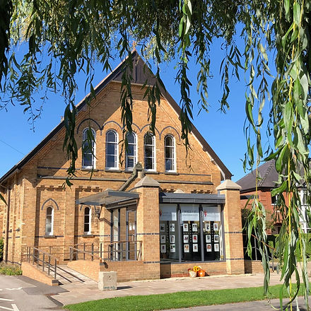 View of the Haxby and Wigginton Methodist Church, looking through willow trees across the Haxby duck pond.