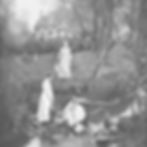 Three pioneer women in white dresses collect water from a stream using buckets. A cottage and two seated women are in the grassy background.