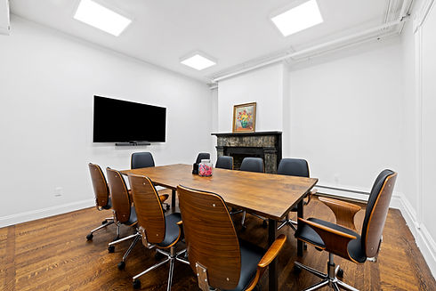 ORW First Floor Conference Room - there is a large table with 10 seats, and a tv with camera on the wall. A historic original fireplace is visible in the rear