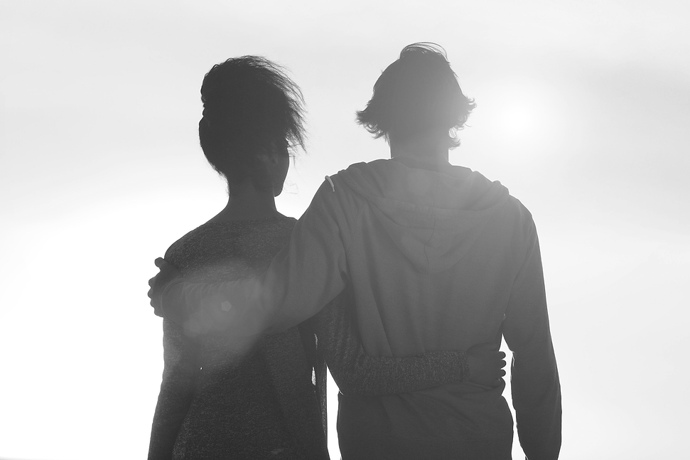 young-couple-embracing-looking-at-sunset