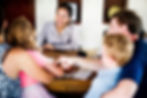BCBA sitting with a family, reviewing a person-centered plan focused on developmental goals, support needs, and individualized care for their child.