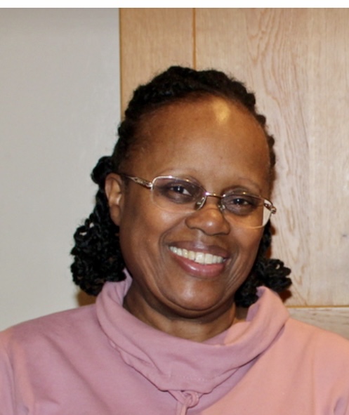 Smiling woman with glasses in a pink shirt, Meet the Team member.