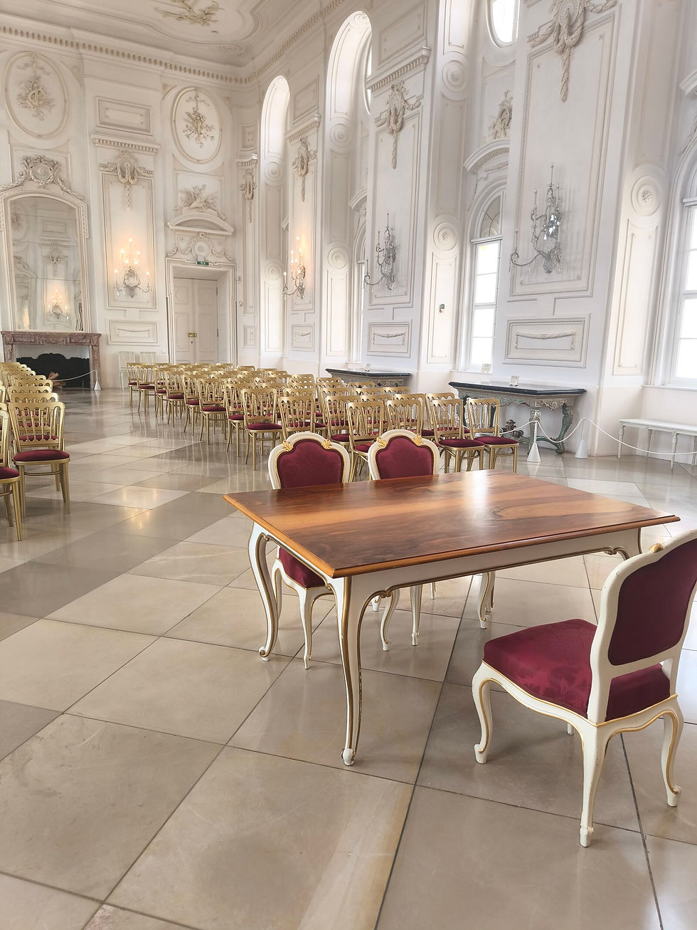 Festsaal von Schloss Hof mit Bestuhlung für eine Hochzeitstrauung und weinroten Samtstühlen am Trautisch