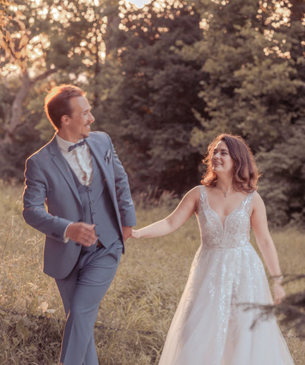 Hochzeit bei Sonnenuntergang. Bräutigam führt die Braut