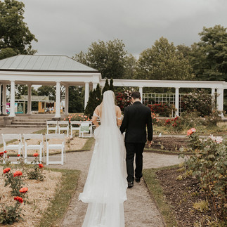 bride and groom walk down the aisle in outdoor garden ceremony