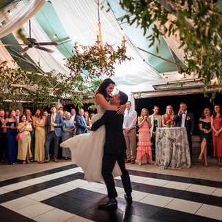 bride and groom first dance in tented outdoor wedding reception