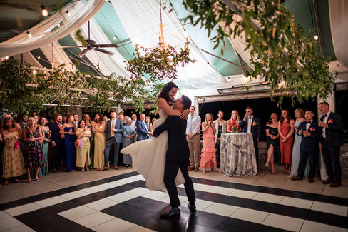bride and groom dance at tented outdoor wedding reception