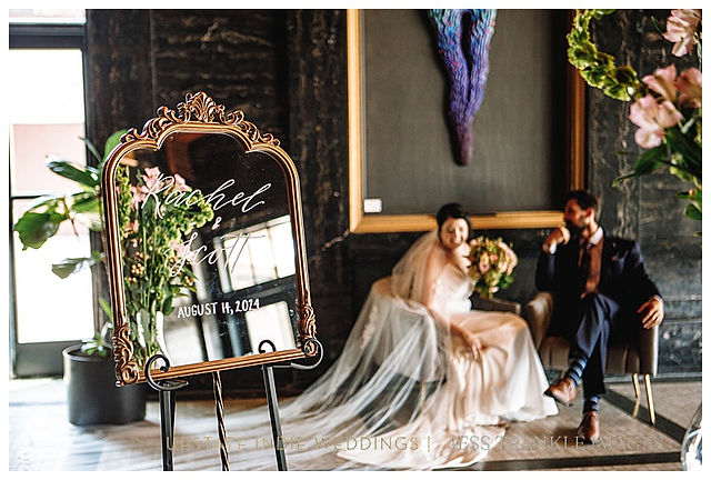 Bride and Groom in Wedding Photo in front of art instatllation and gilded mirror