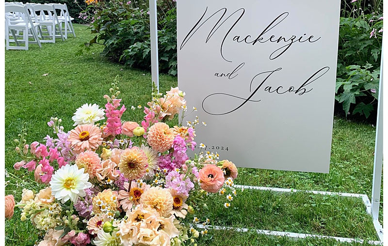 welcome sign for wedding with pink and peach floral display