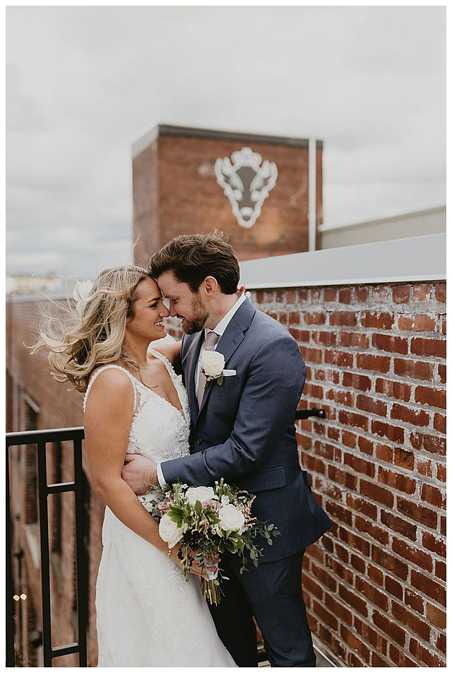 bride and groom share a moment on rooftop of Resurgence Brewing wedding reception