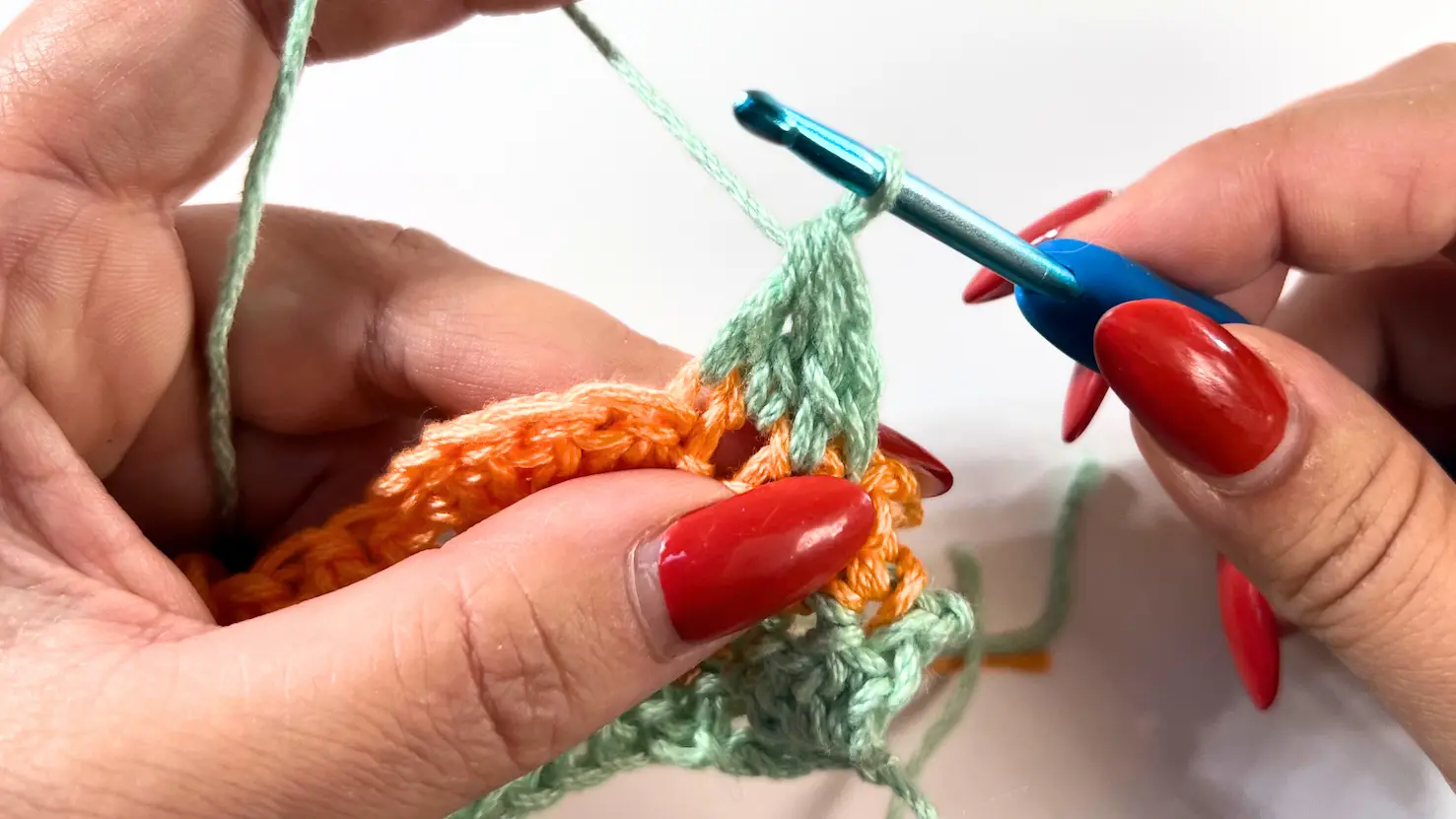 Four partial double crochets worked into the next three stitches, forming the beginning of a 4DC cluster with four loops visible on the hook.