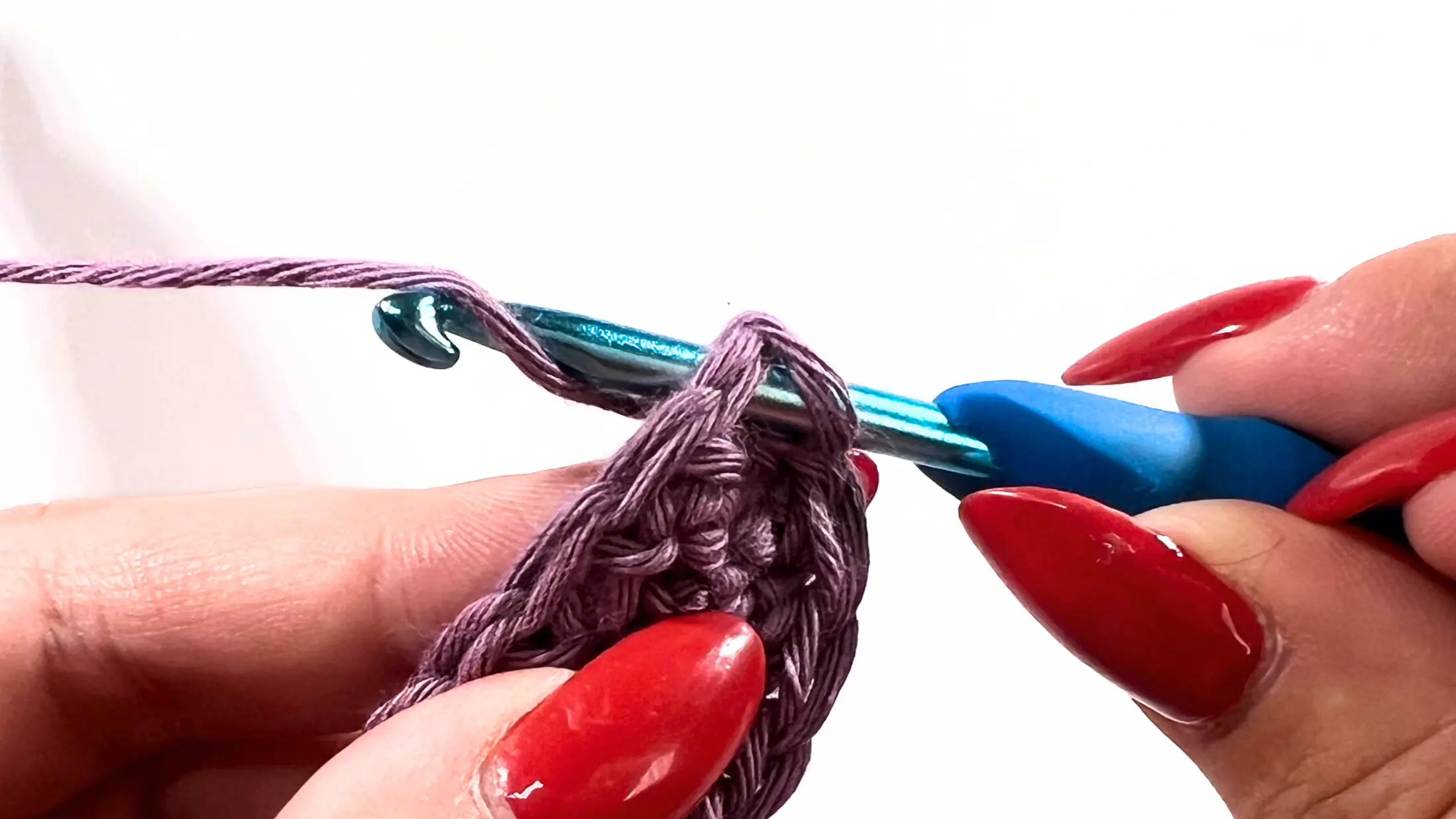 Crochet hook and yarn forming seamless edge with invisible join method.