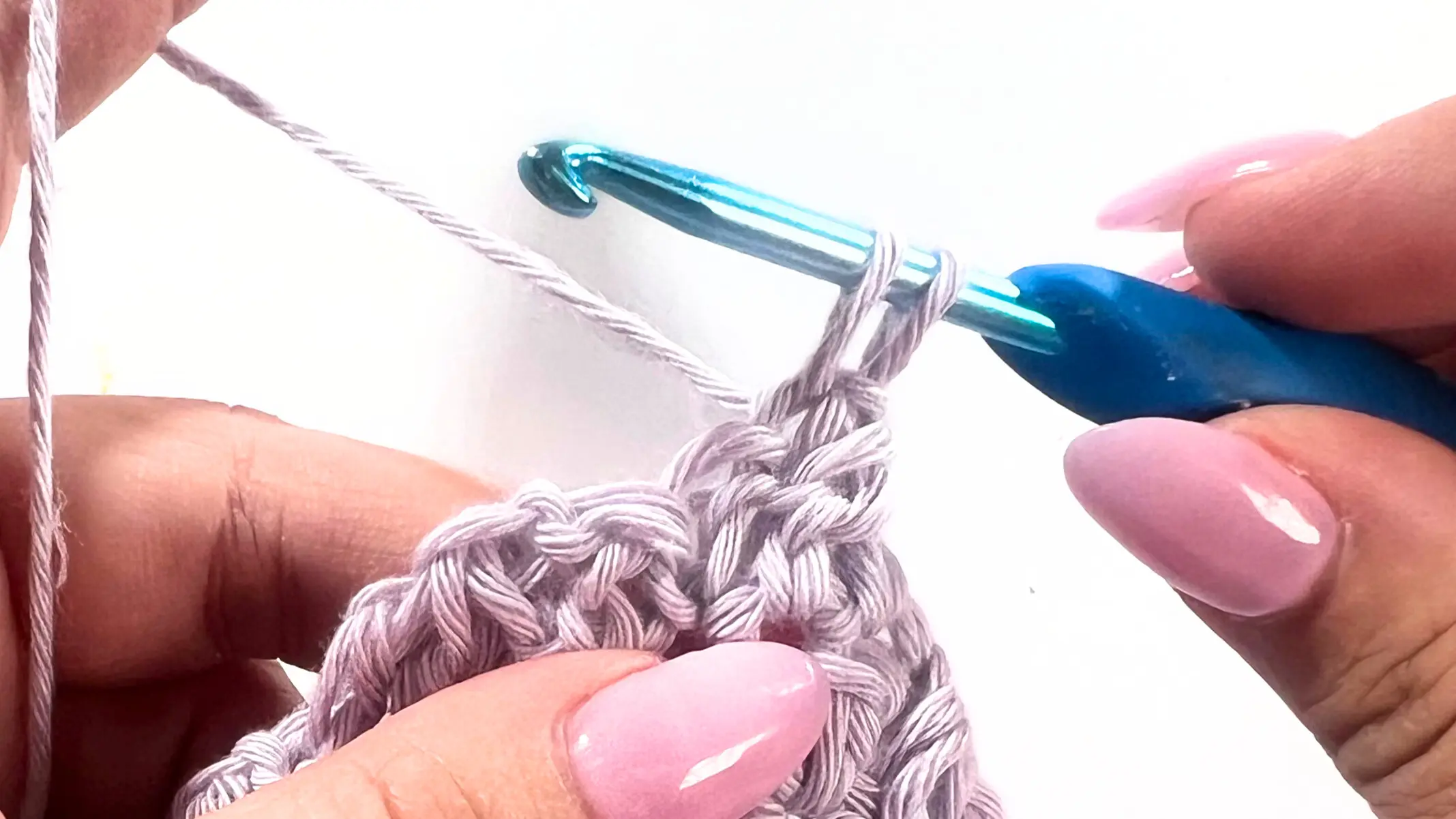 Crochet hook with yarn over, inserted into the first stitch to begin SC3tog decrease in C2C Lemon Peel Stitch.