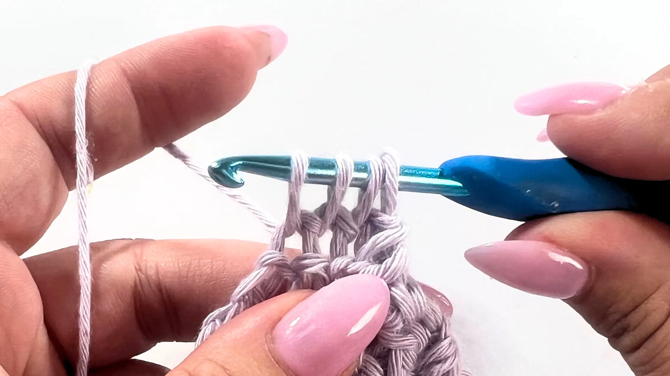 Crochet hook inserted into the third stitch, with four loops now on the hook, preparing to finish SC3tog decrease.