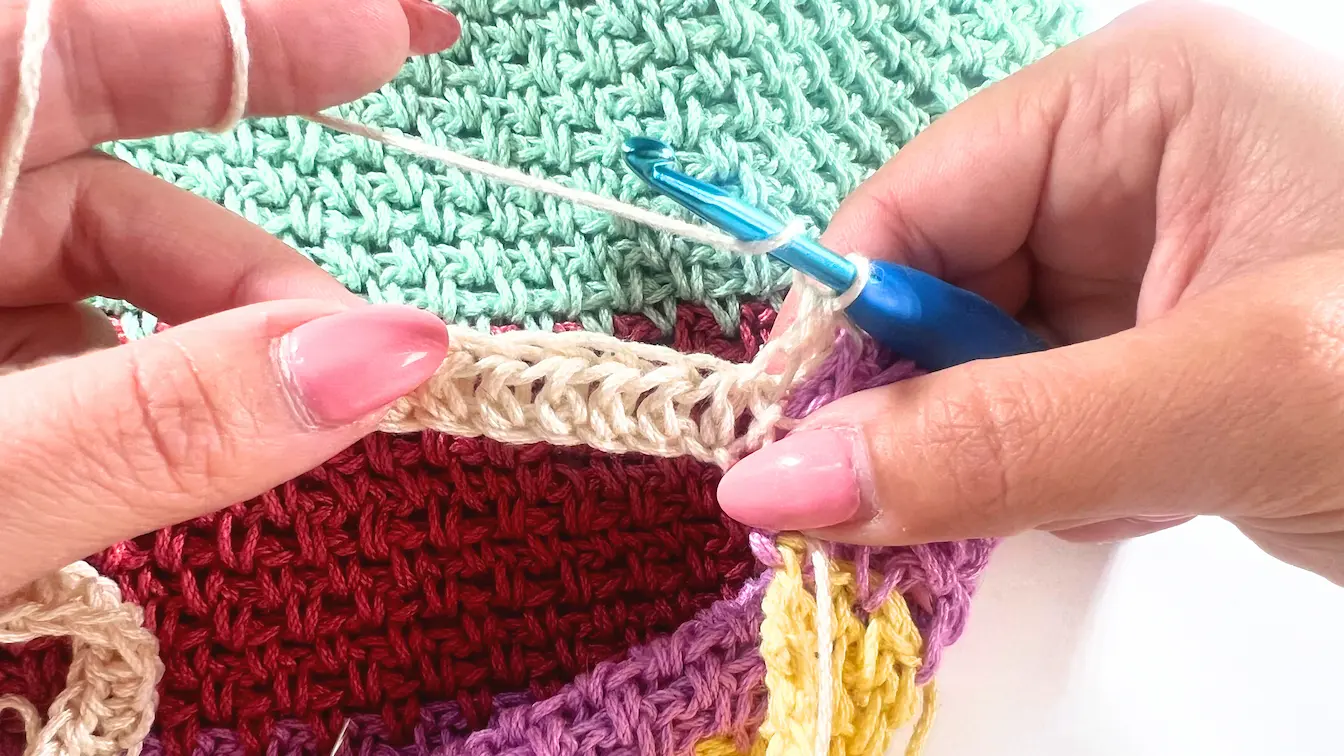 Close-up of sleeve row crocheted and joined with a slip stitch into the side of the striped panel, showing how the sleeve attaches neatly along the edge.