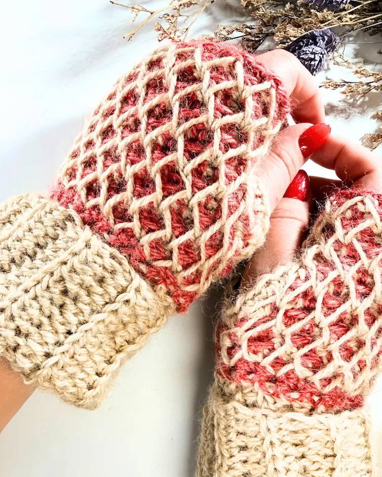 Honeycomb fingerless crochet gloves worn on hands, showing textured stitch pattern and ribbed cuffs.