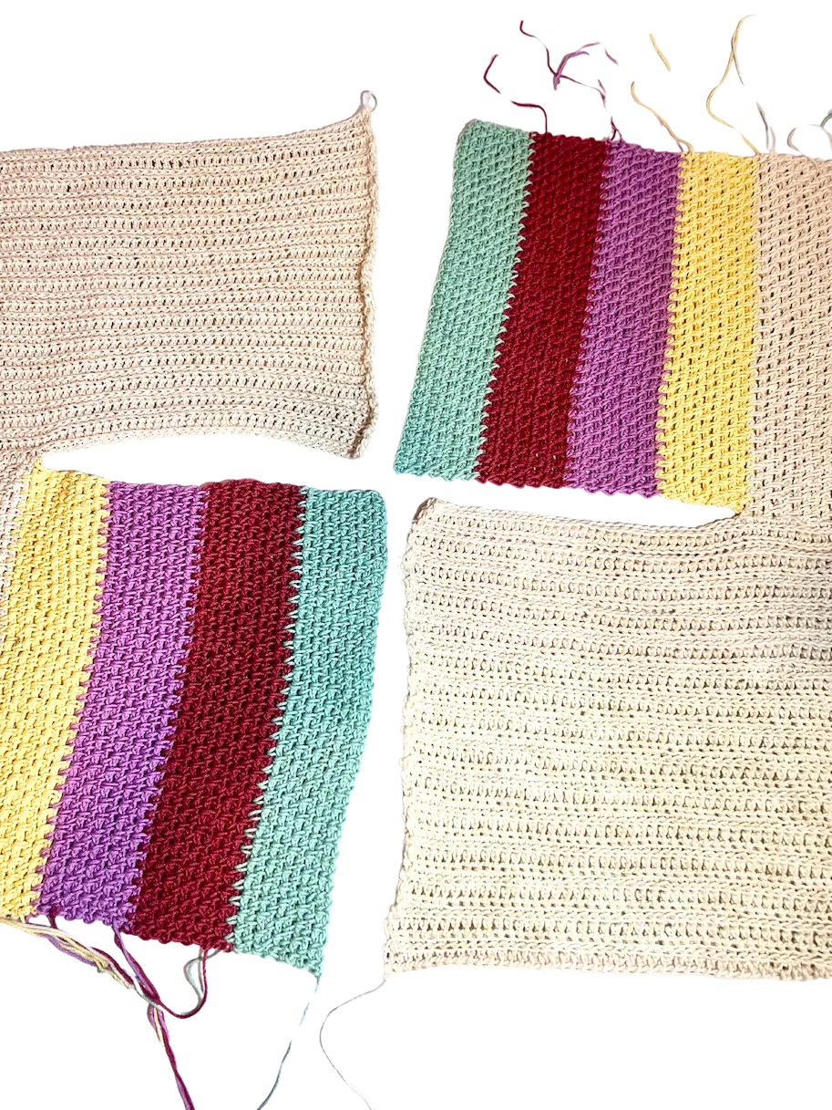 Four crochet pieces arranged flat, showing the front and back panels of the sweater with shoulders aligned and ready to be seamed together.