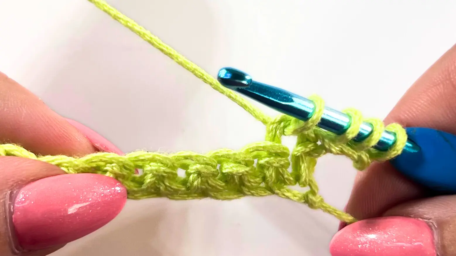 Hook pulling up loops through the next chains, increasing to four loops on the hook.