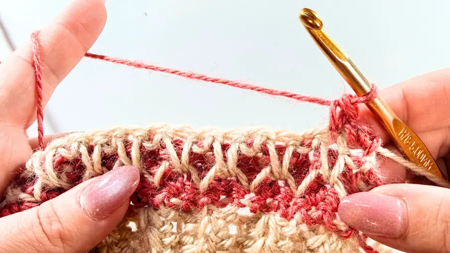 Honeycomb stitch crochet step showing how to connect the legs of the spike stitches across the row