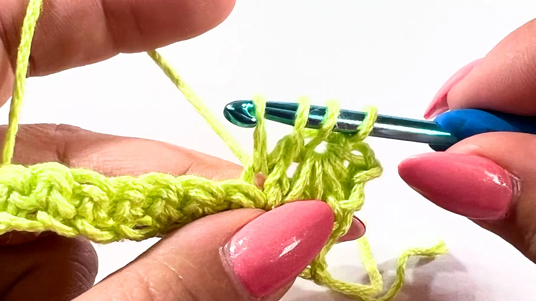 Building loops from the previous stitch and the next two chains, progressing toward six loops on the hook.