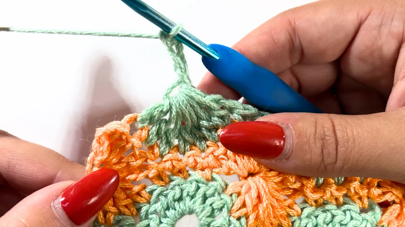 Close-up of the new row starting with a chain 3, preparing to continue the Catherine Wheel Stitch pattern across the row.