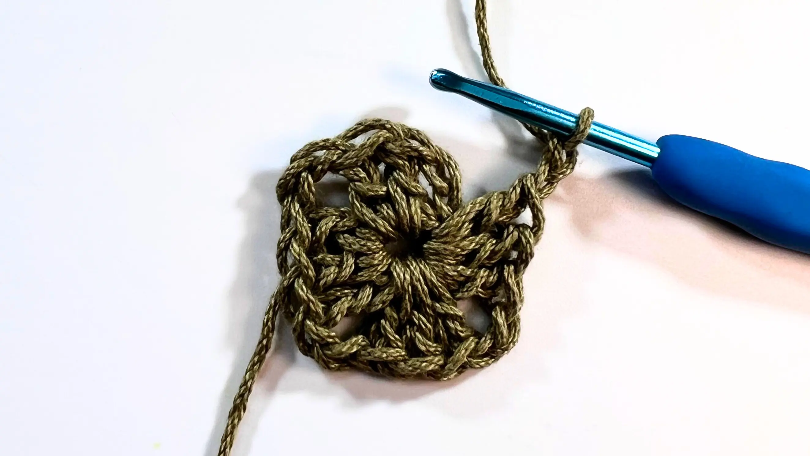 Almost finished first round of granny square with hook at the top corner, ready to join.