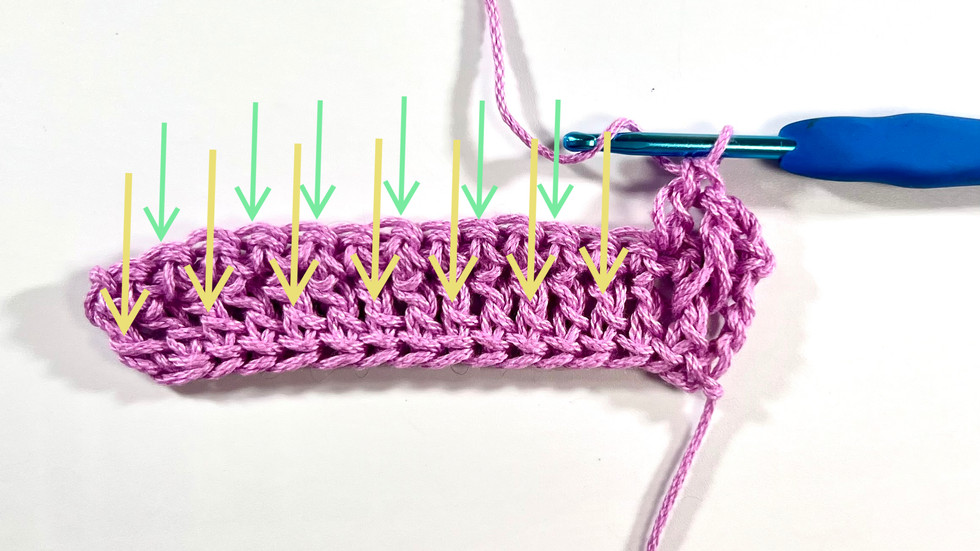 Arrows indicating alternating stitches for the rest of the row of the Alpine Stitch. Pink yarn and blue hook on a white background.