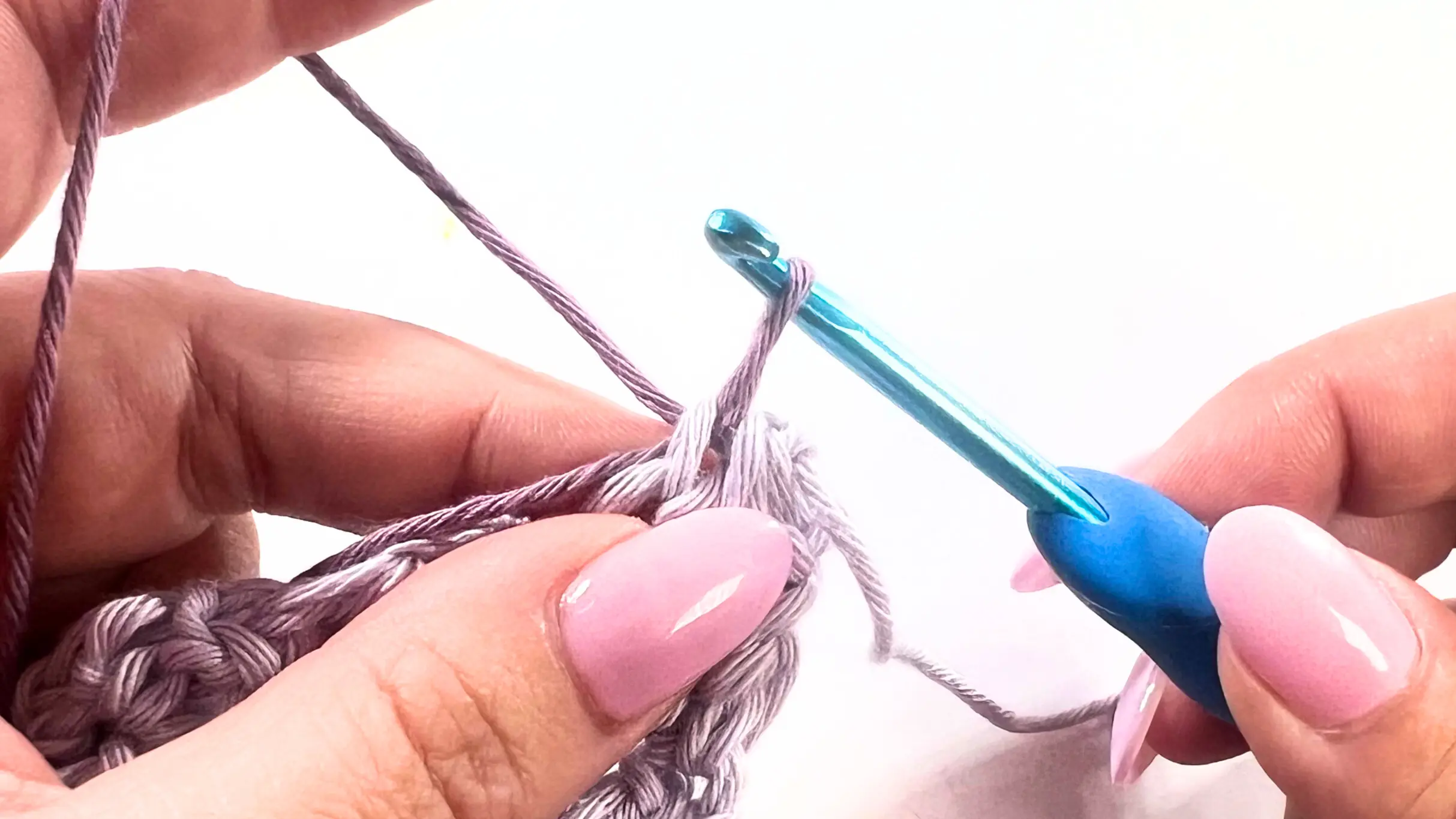 Crochet hook pulling the new yarn colour through the first stitch to secure the join for the Picot Border.