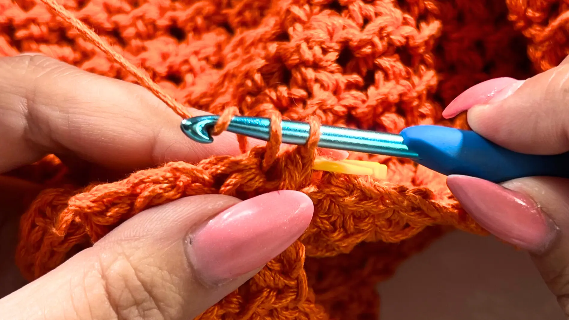 Close-up of working a single crochet into the marked stitch to firmly join the strap to the opposite side of the crochet top.