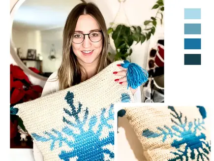 Crocheted Northern Flakes pillow case with a snowflake colourwork motif and tassels on the corners.