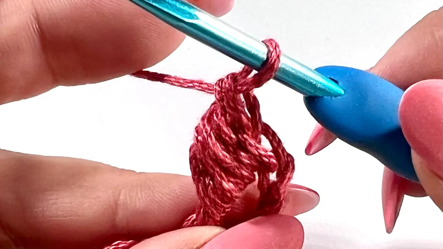 Completed crochet bead stitch after pulling through the last 2 loops, showing the finished textured puff.