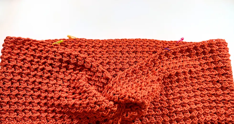Full view of burnt orange crochet piece after creating the twisted front, ready for the next steps in the summer top assembly.
