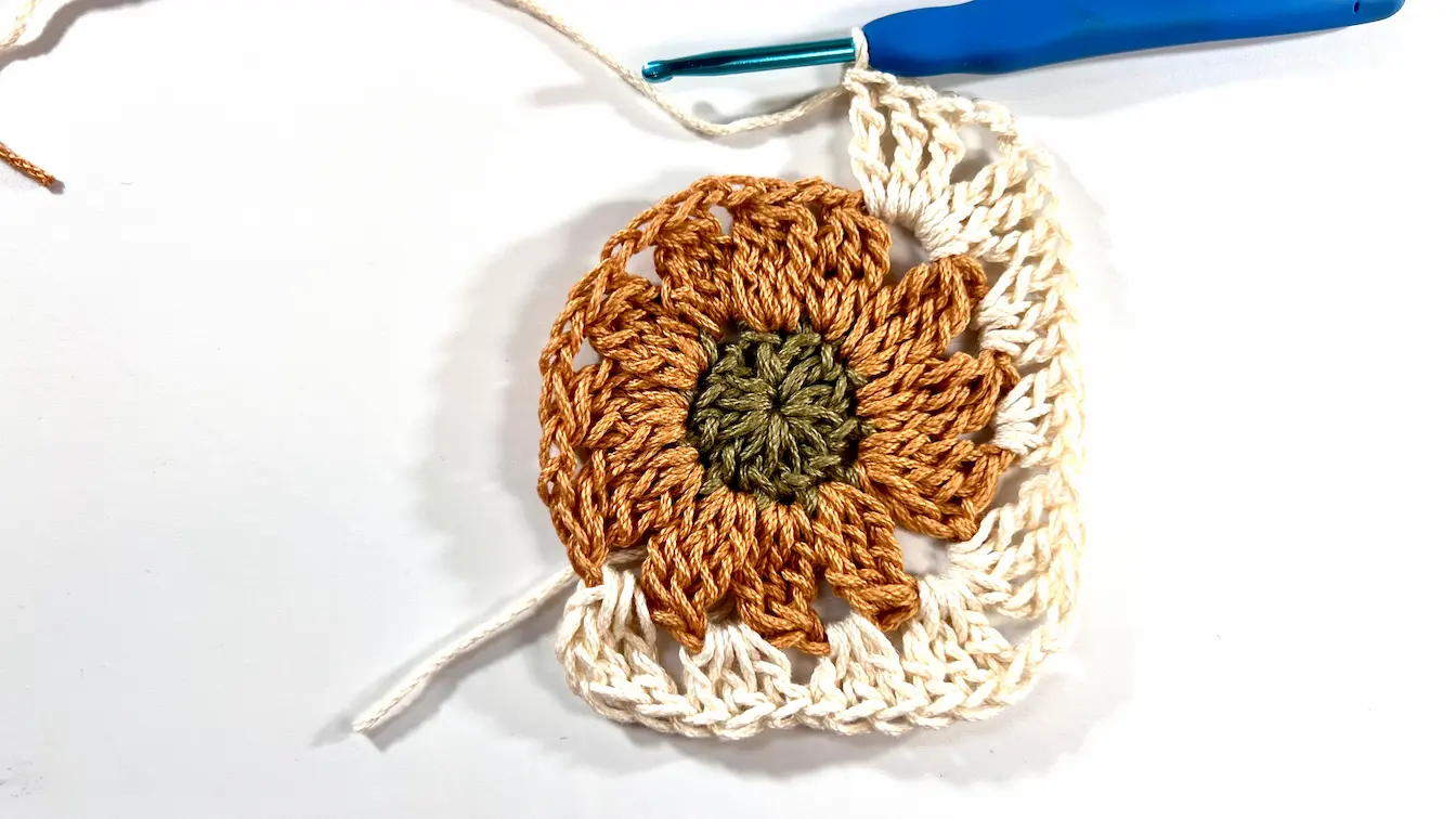 Finished Daisy Granny Square with all four corners worked, forming a complete square.