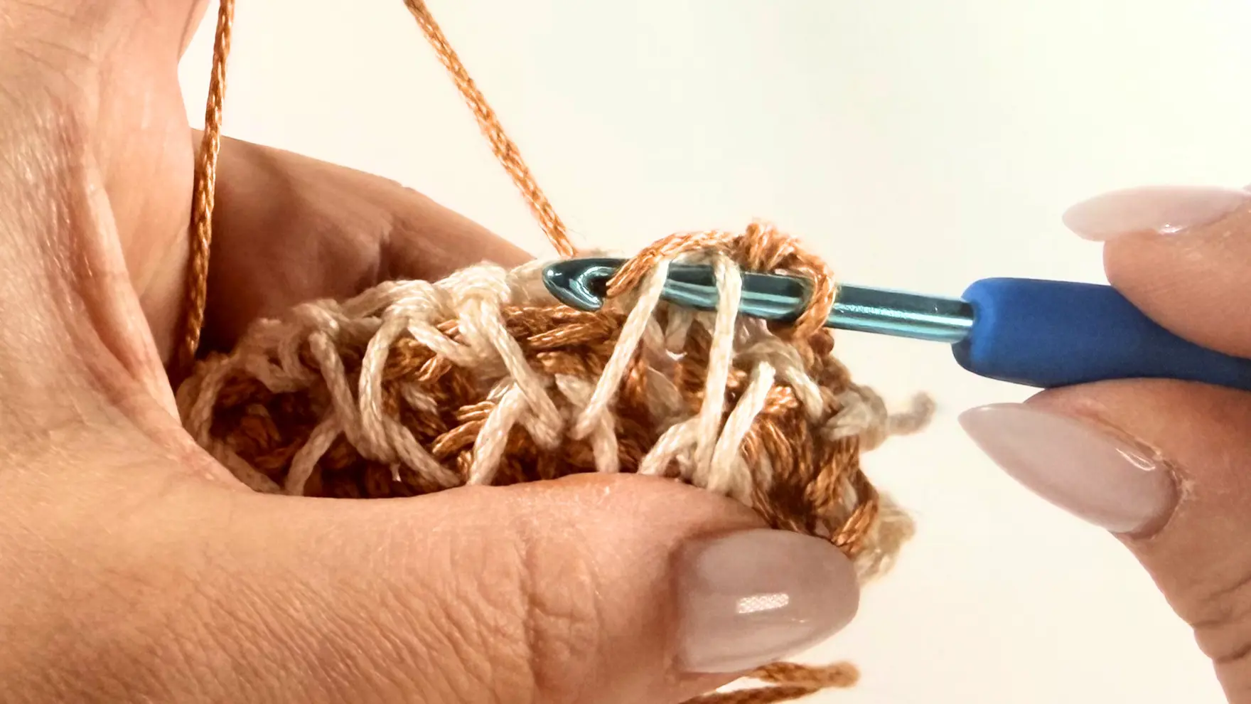 Sliding the crochet hook under the two legs of the Spike Stitch to create the Honeycomb texture.