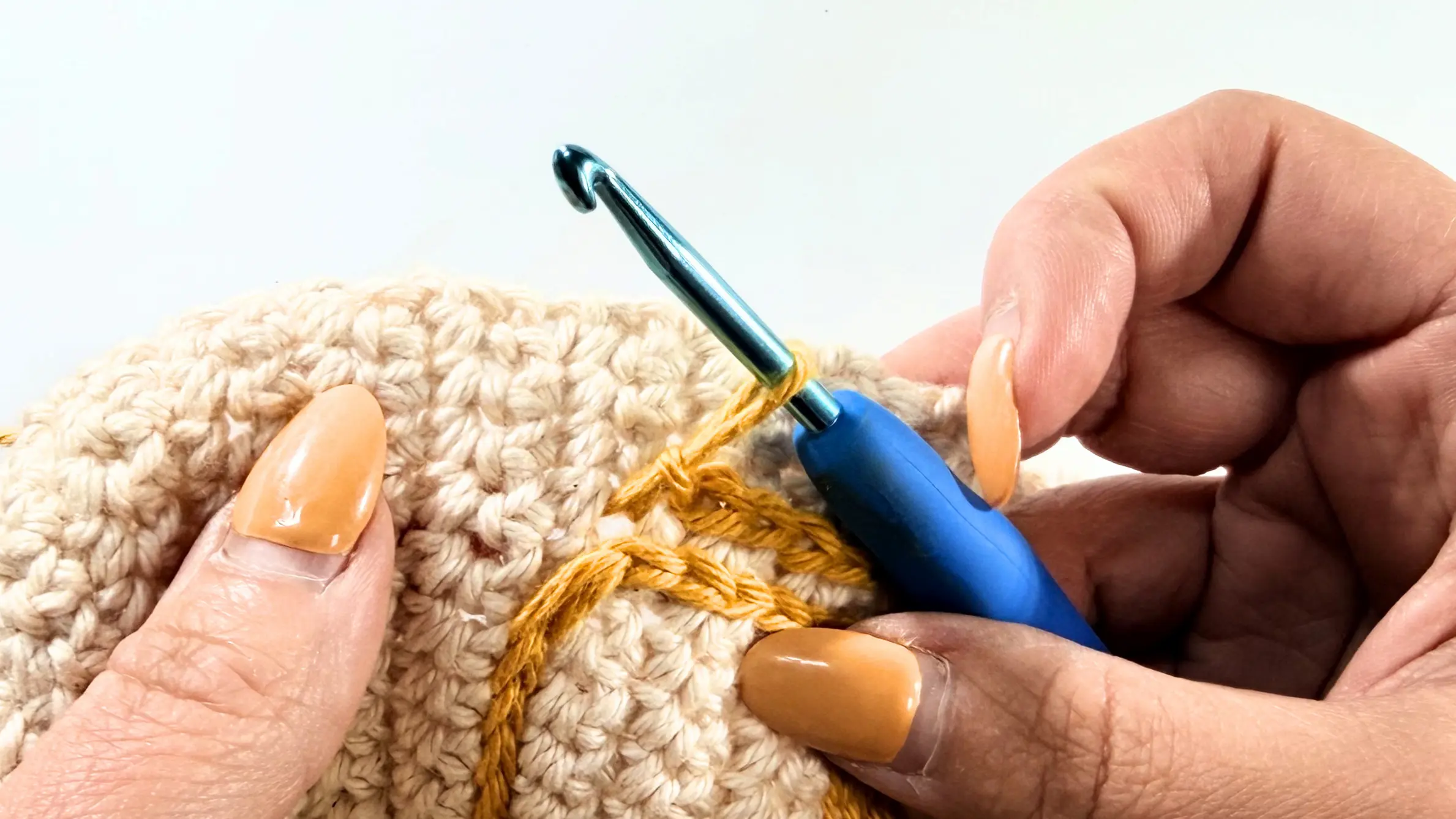 Pulling up a longer loop before fastening off the surface crochet design.