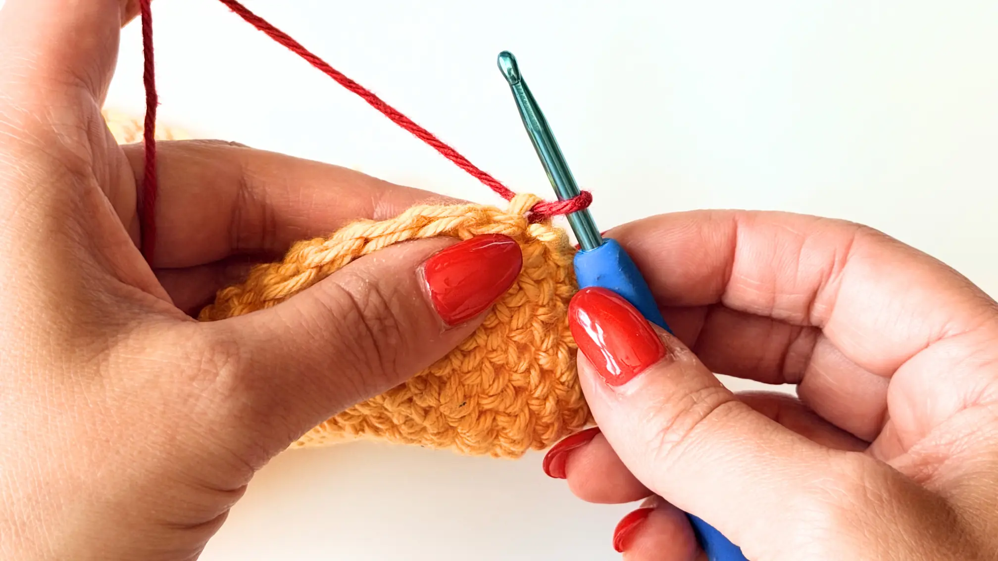 Attaching Colour B (Red) to begin the first invisible Double Crochet.