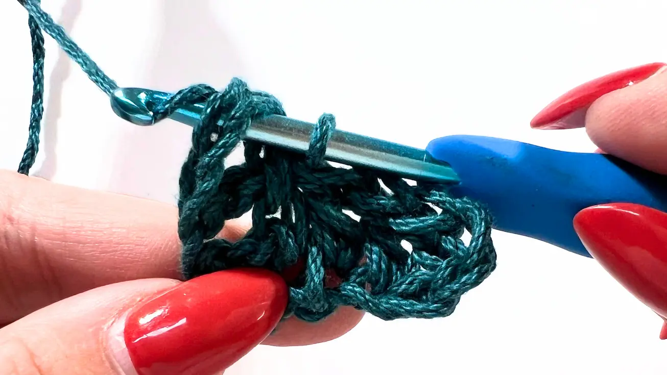 Crochet C2C tutorial – close-up of crochet hook working slip stitch into space to join new square.