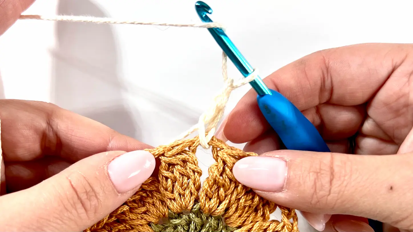 Starting the third colour round on the Daisy Square by attaching cream yarn into a chain space.