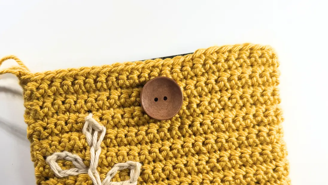 Button attached to the center of the crochet Kindle sleeve for the button closure option.