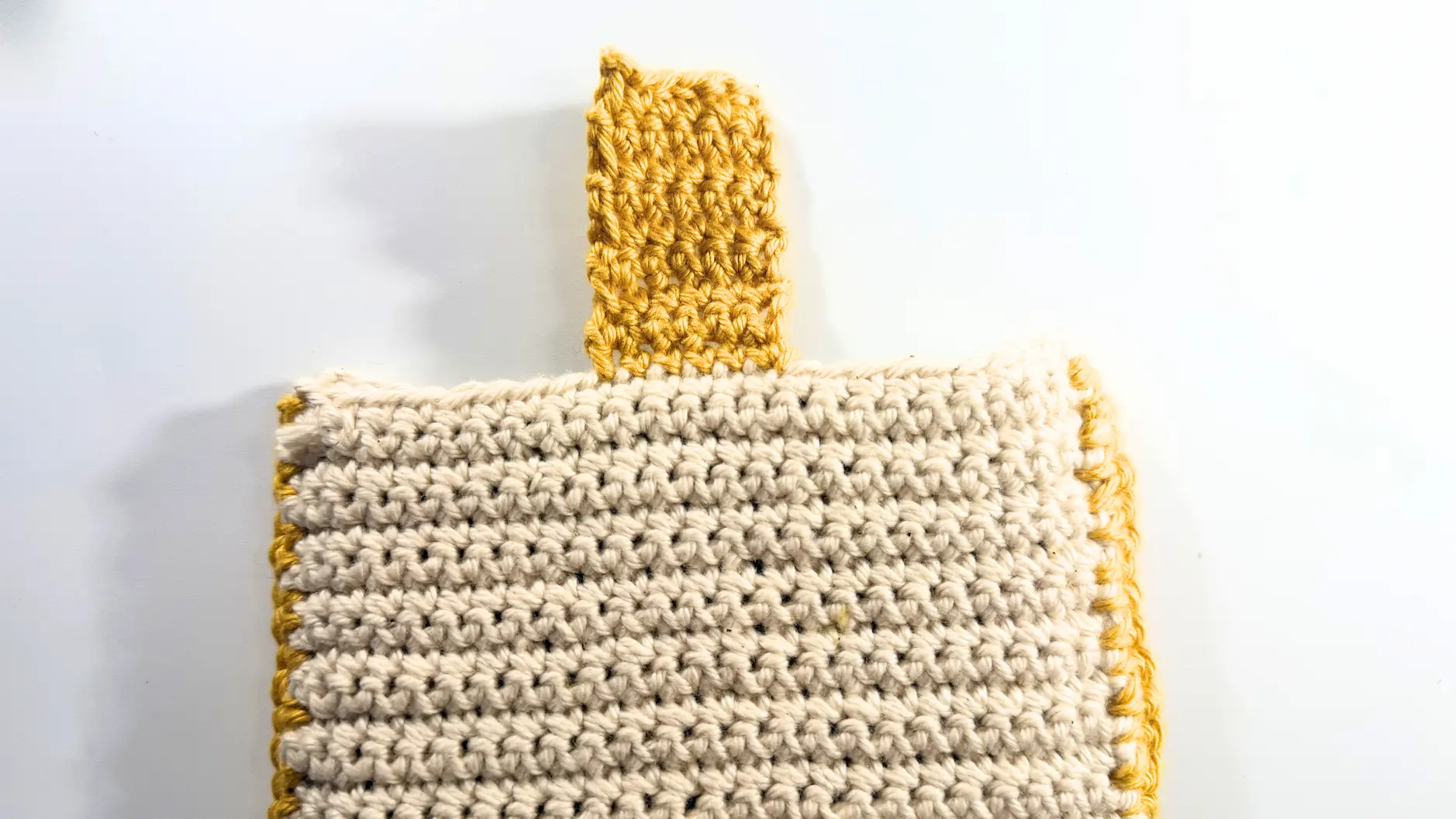Crochet strap worked at the center of the sleeve to create a magnetic button closure.