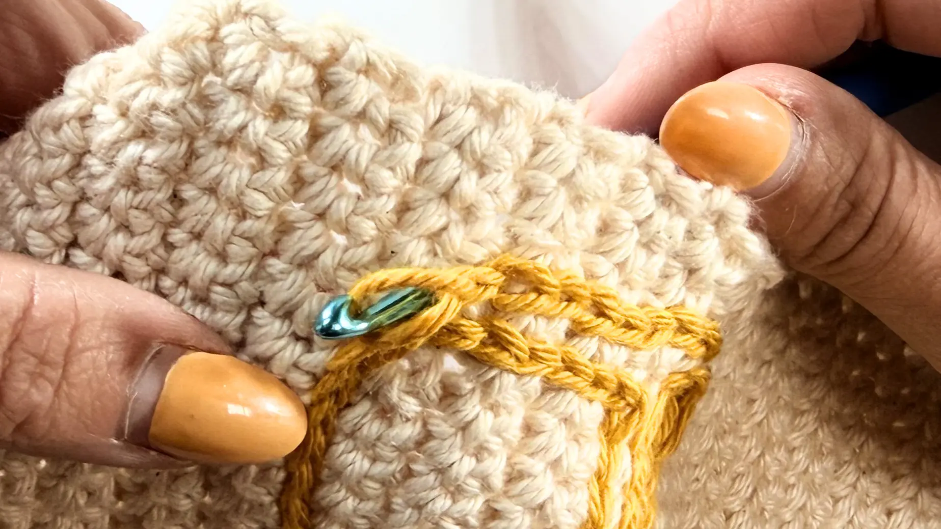 Inserting the hook from the back to pull the surface crochet loop through to the wrong side.