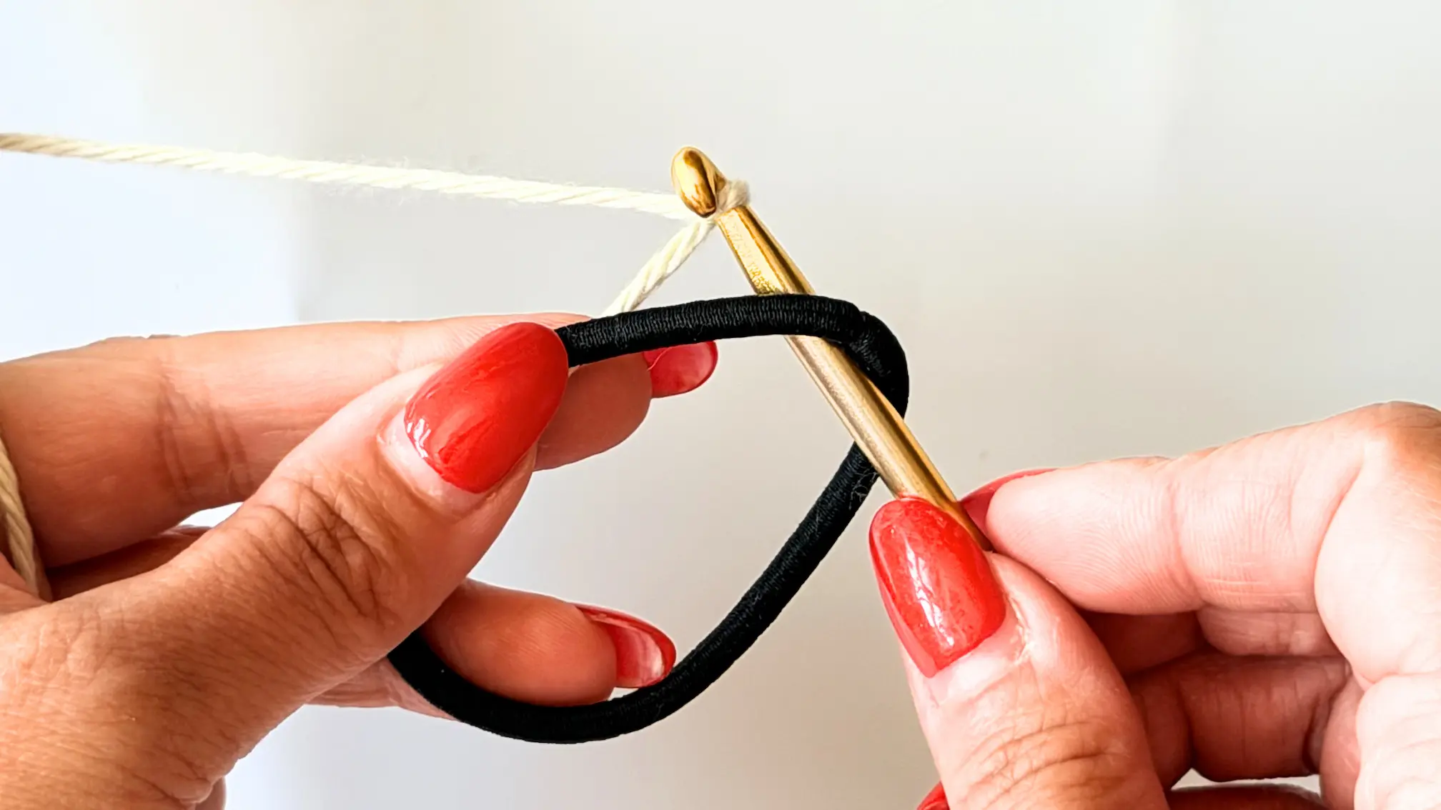 Starting a crochet scrunchie by attaching yarn to a hair elastic