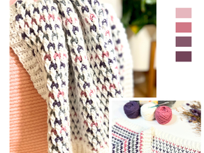 The Cuddle Blanket Crochet Pattern — a soft and textured baby blanket made with white, pink, grey, and purple yarns, draped over a chair and shown flat with crochet supplies beside it. Free crochet pattern by Happy Heartsy.