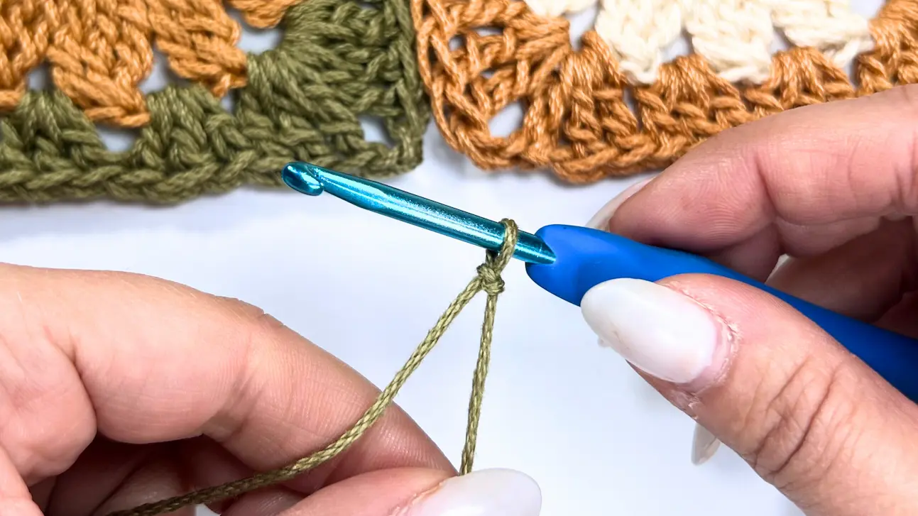 Starting a new yarn with a slip knot on the hook, ready to begin joining granny squares for the Meadow Daisy Bag.