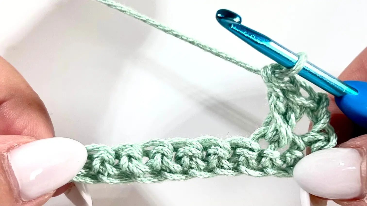 Two crossed double crochet stitches forming an X shape, demonstrating the main texture of the Crossed Double Crochet technique.