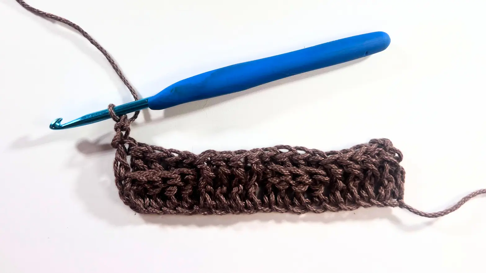 Completed first row of the basket weave stitch pattern, showing alternating blocks of Front Post and Back Post Double Crochets (FPDC and BPDC).