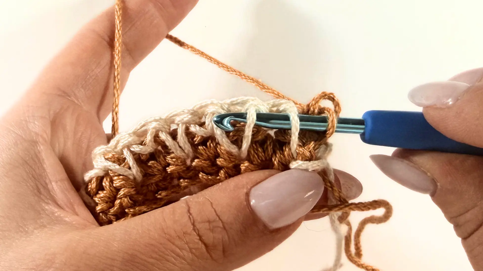 Sliding the hook under the two legs.