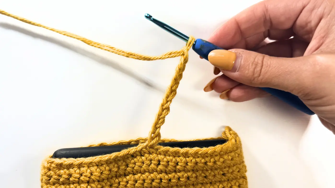 Creating a chain loop for the button closure on The Cozy Reader Sleeve.